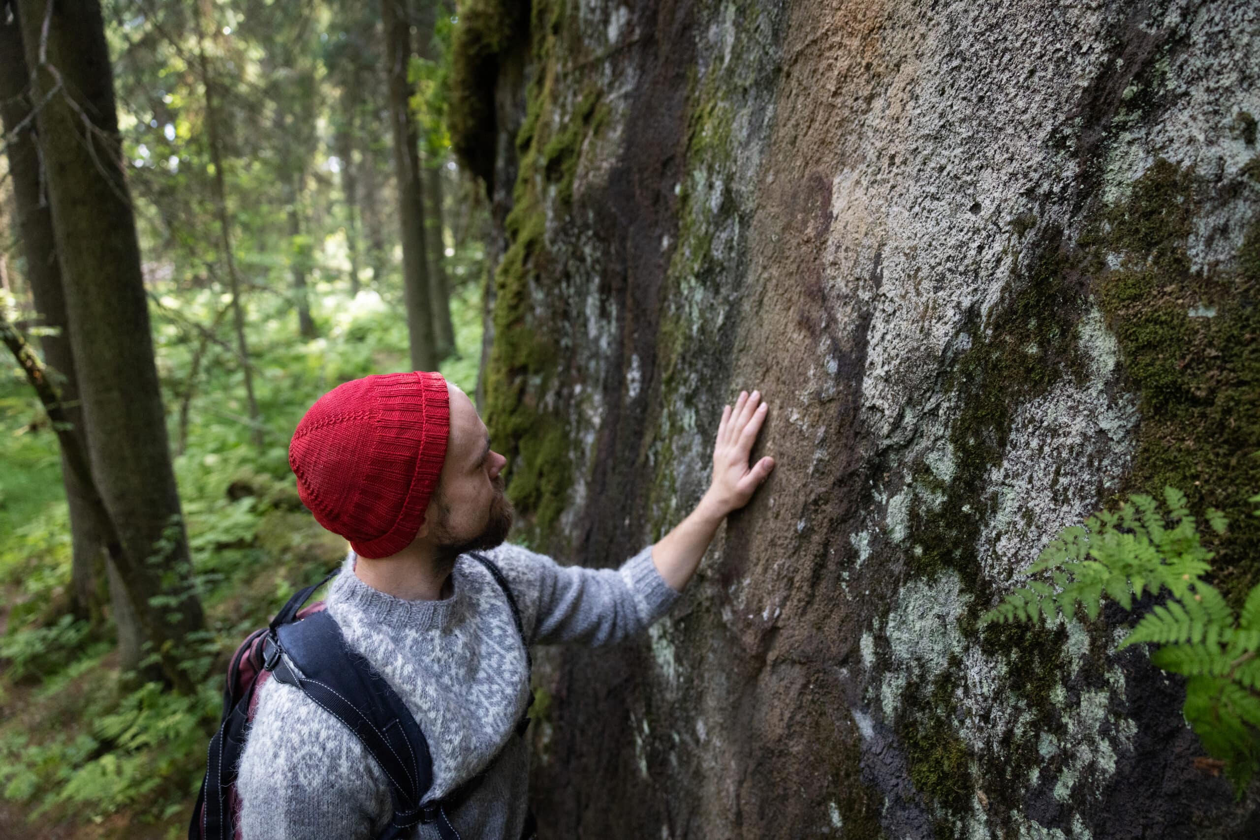 Retkeilijä tunnustelee kalliota Synninlukossa.