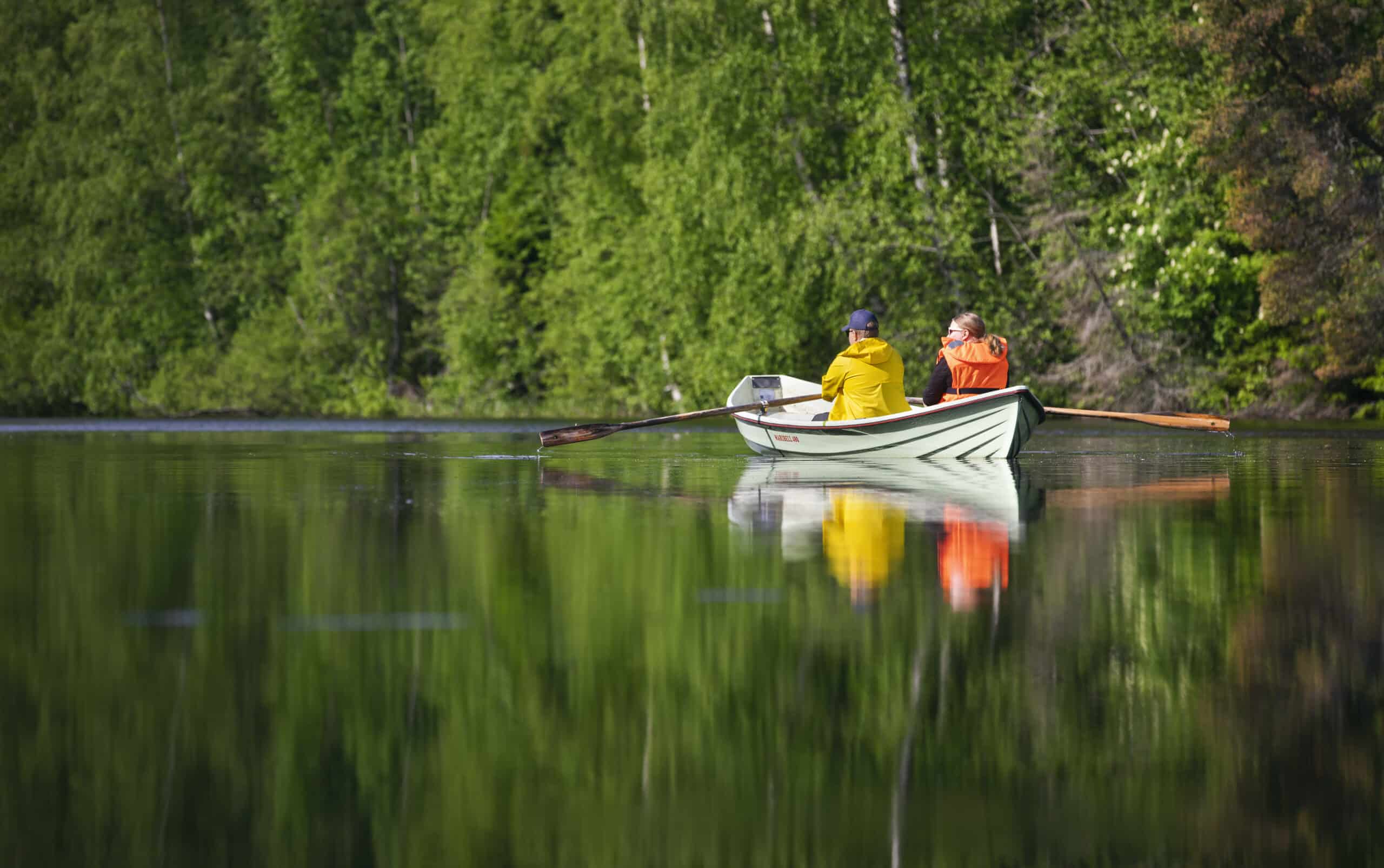 Henkilöt soutaa tyynellä järvellä