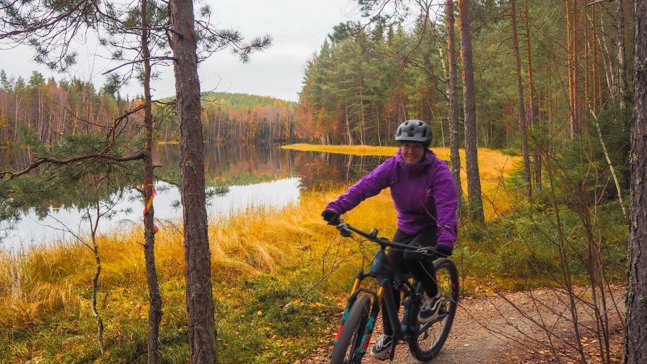 Nainen retkipyöräilee ja katselee maisemia järven Sorvajärven rannalla.
