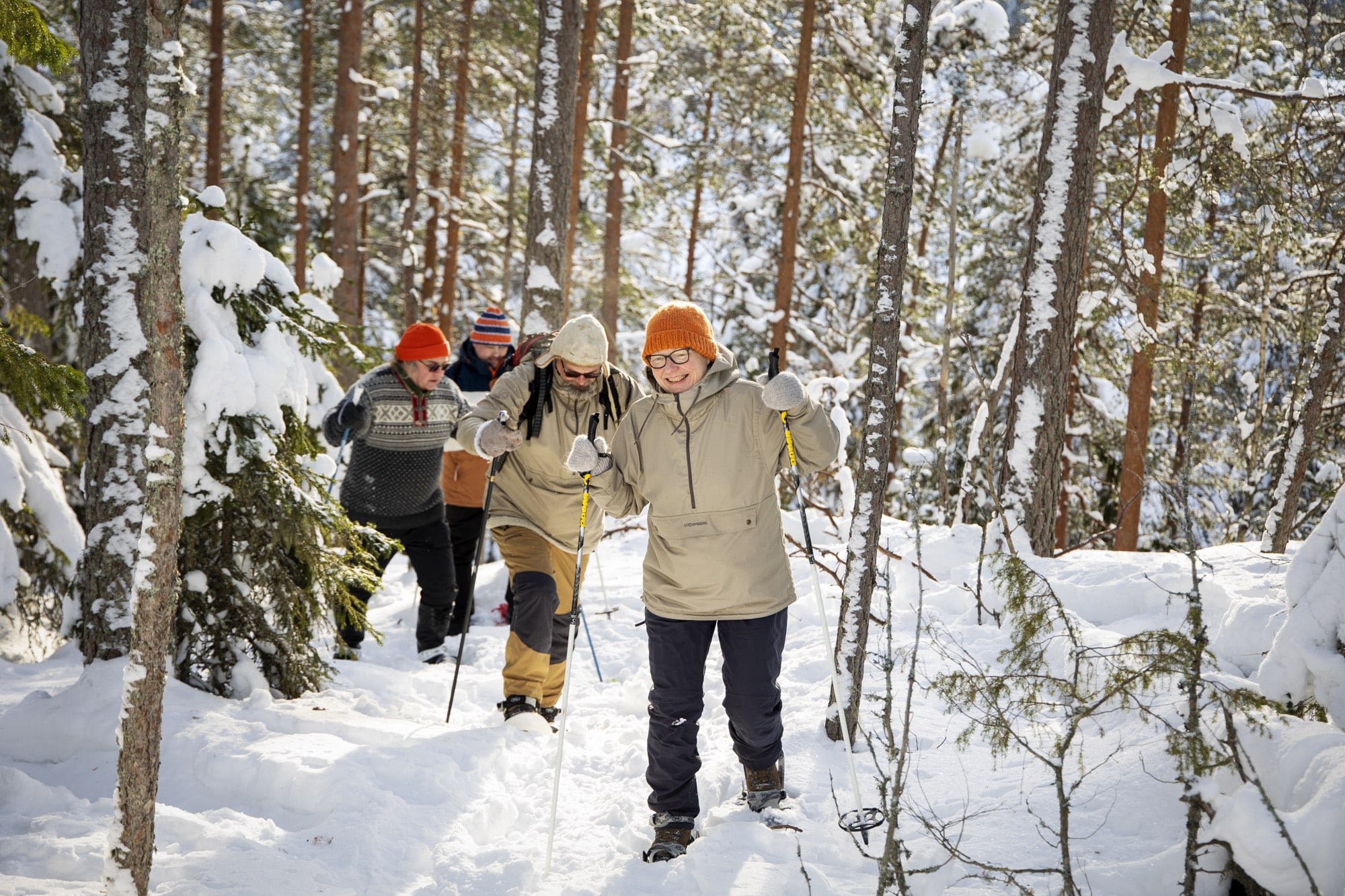 Ihmiset lumikengillä metsässä