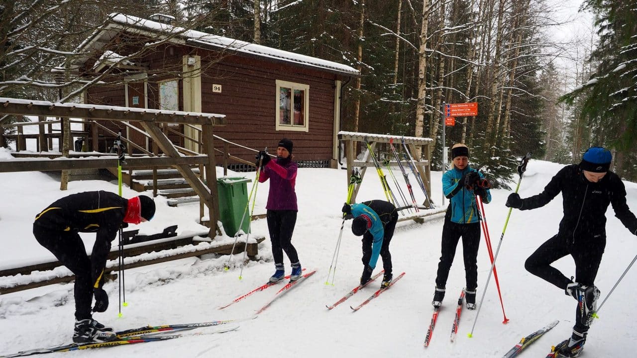 Hiihtäjät hiihtomajalla laittamassa suksia jalkaan