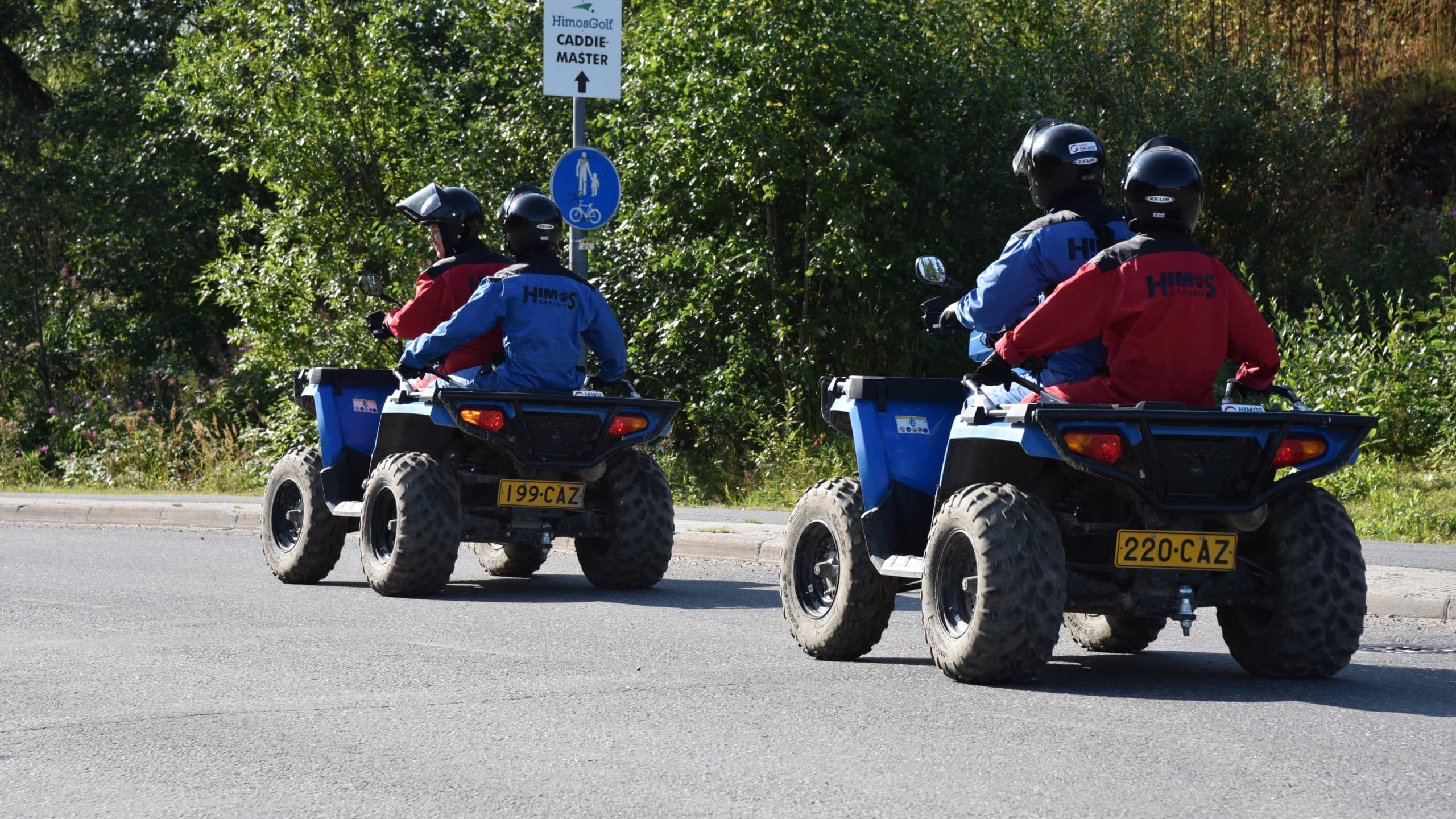 Kaksi mönkijää kesällä asfaltilla ajamassa peräkkäin