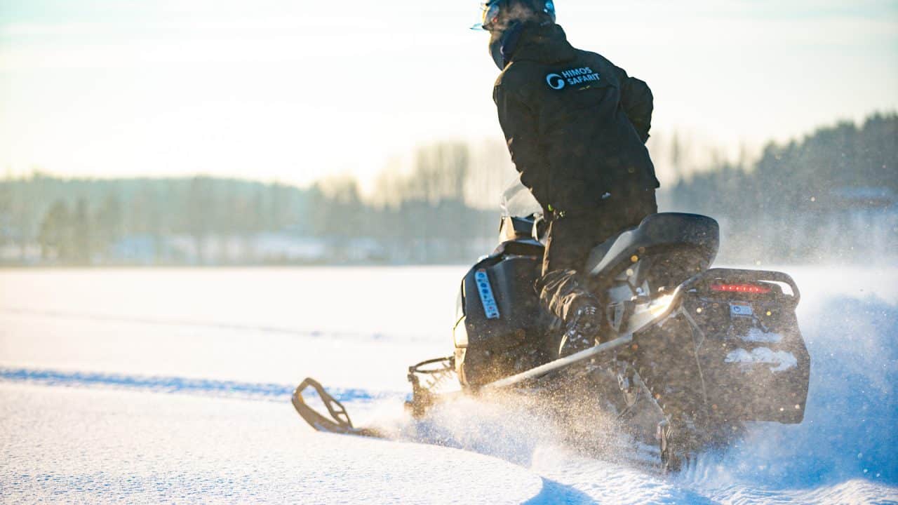 Moottorikelkkailija kurvaamassa hangessa