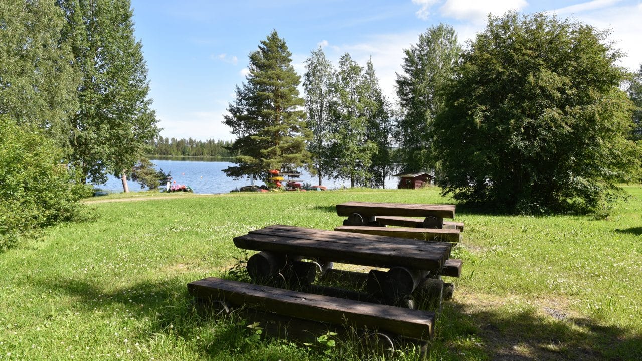 Pöydät kesäisellä Rantapirtin pihan nurmikolla