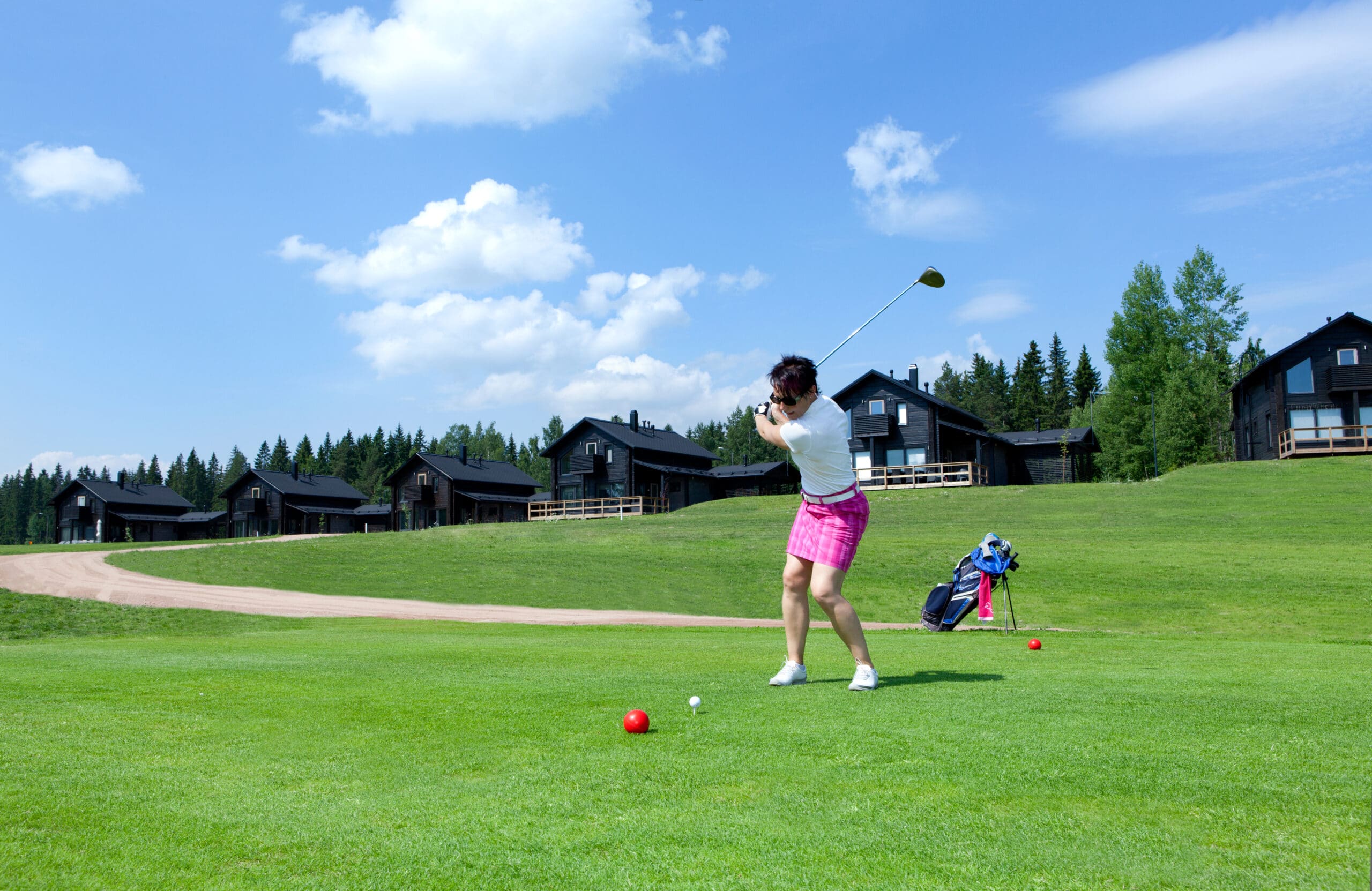 Nainen lyö golfpalloa