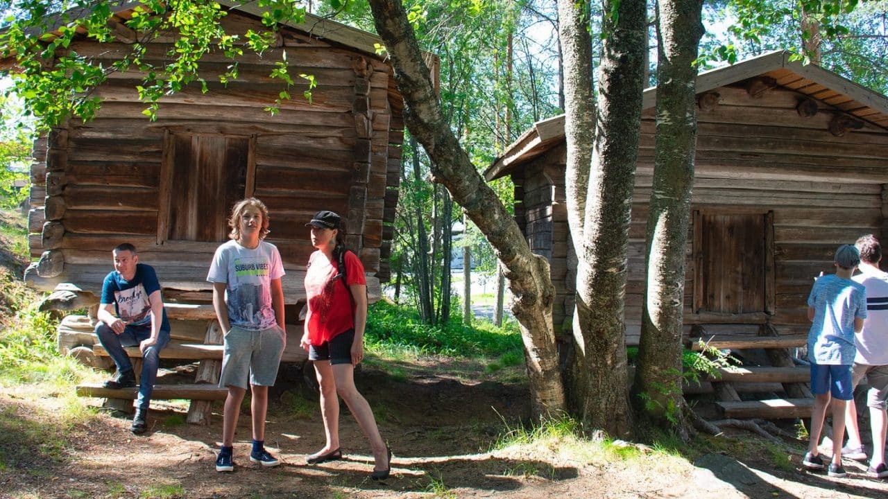 Museon kävijät vanhojen torppien edessä