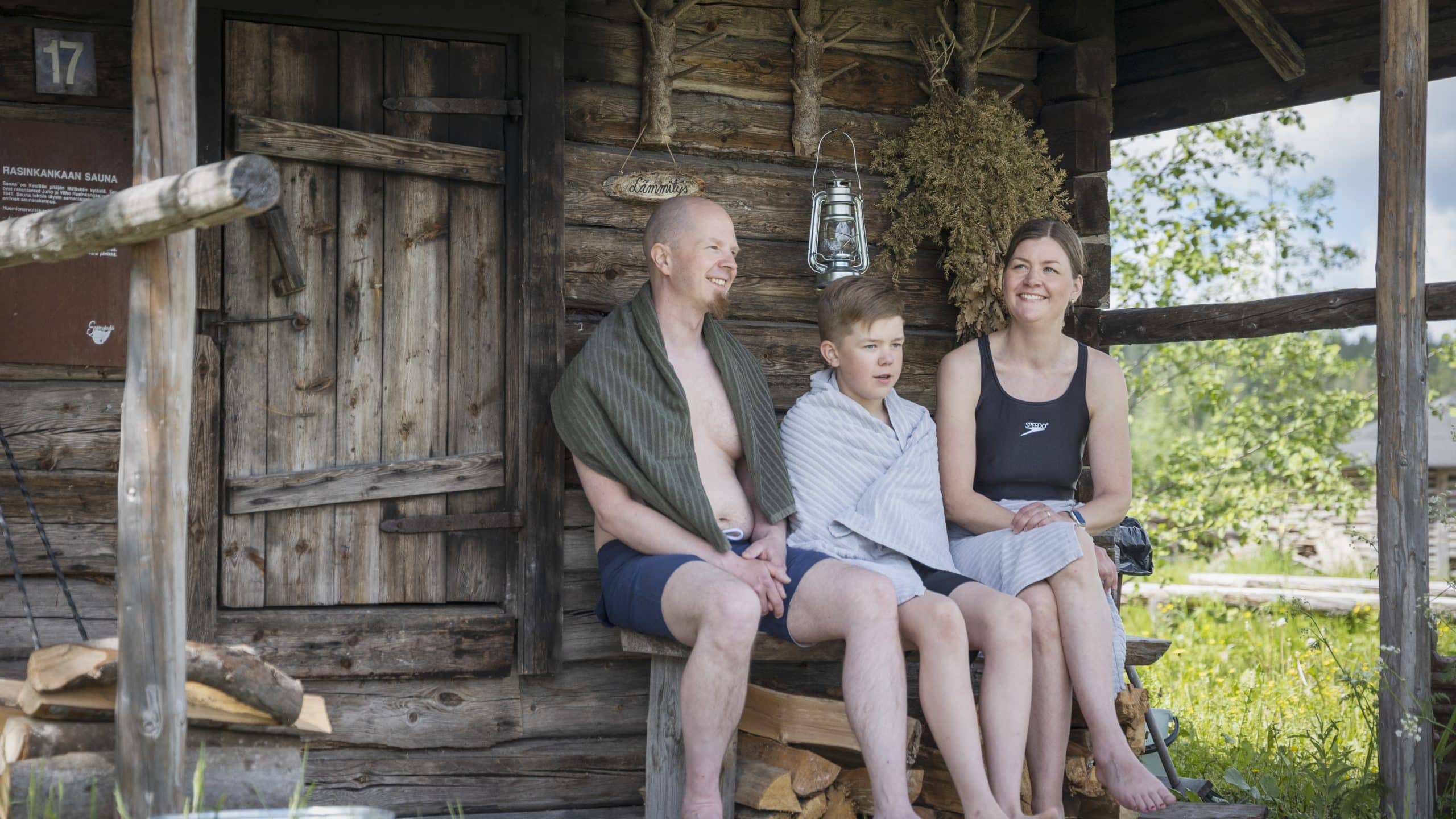 Perhe vilvoittelemassa saunan kuistilla