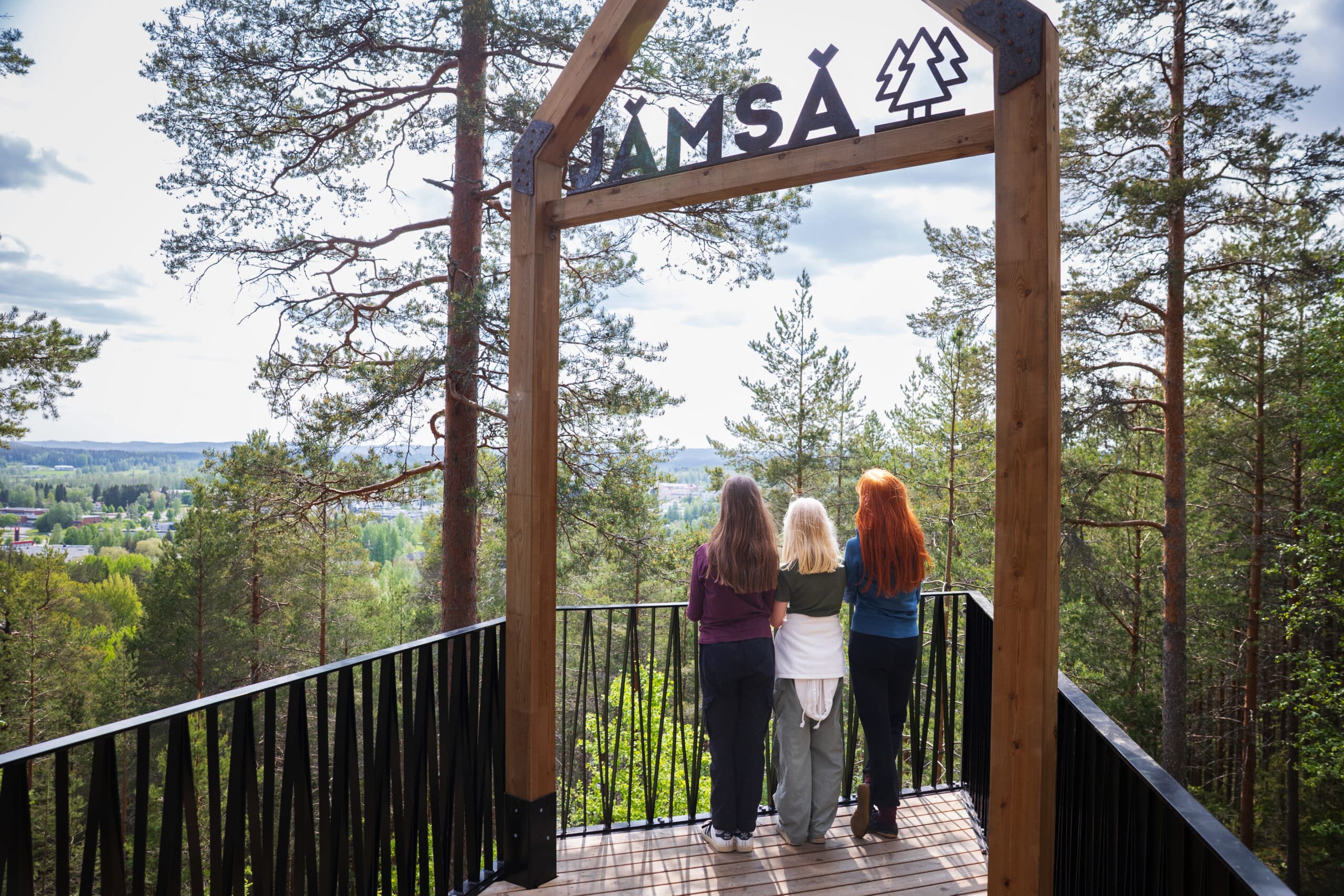 Kolme retkeilijää katsoo maisemia Pukinvuorella