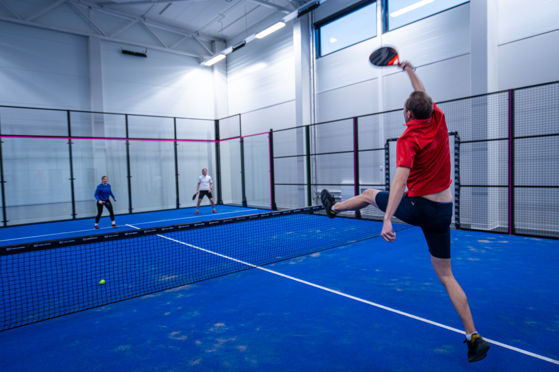 Mies pelaa padelia HimosLomien sisäkentällä.