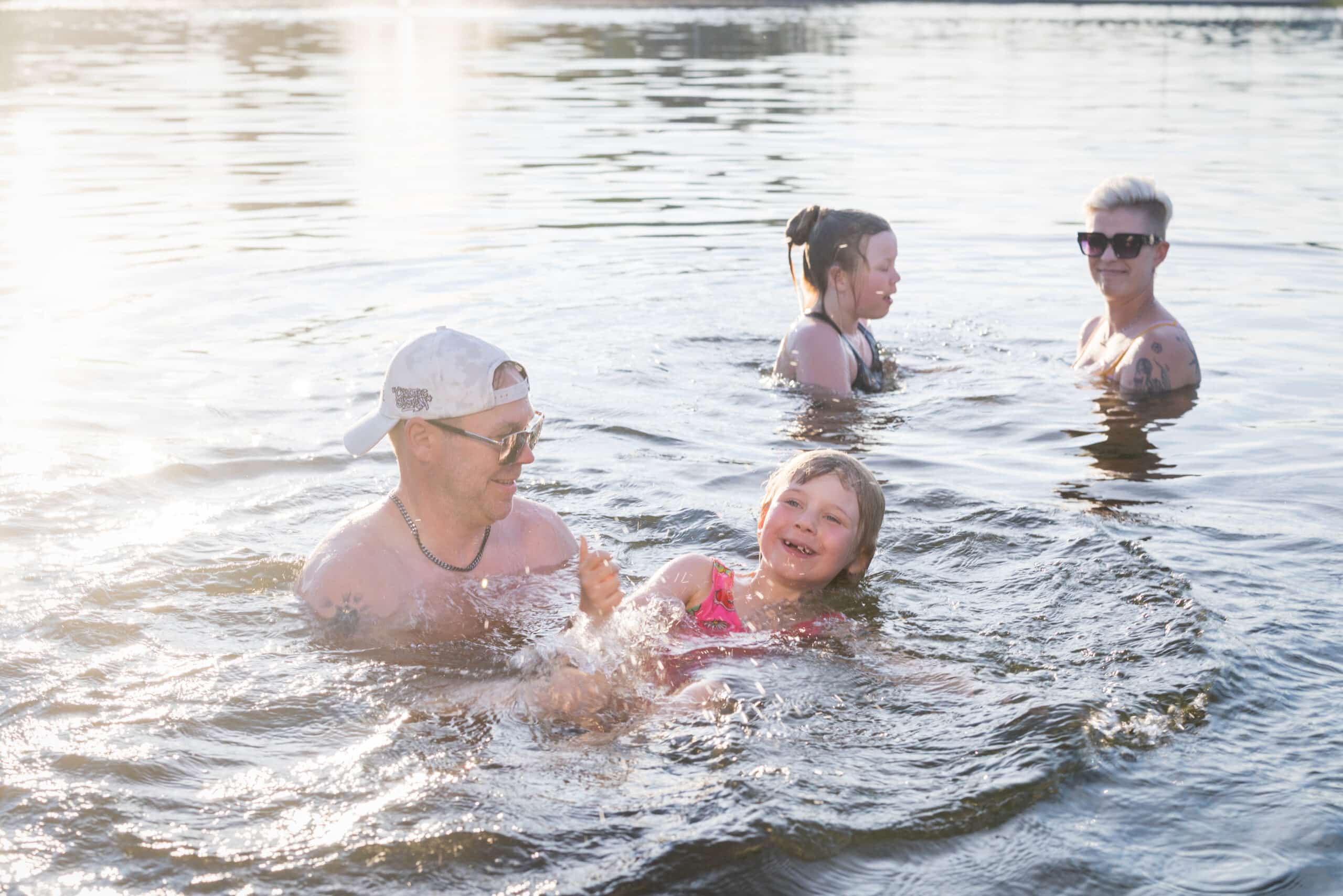 Nelihenkinen perhe uimassa maauimalalla Jämsässä.