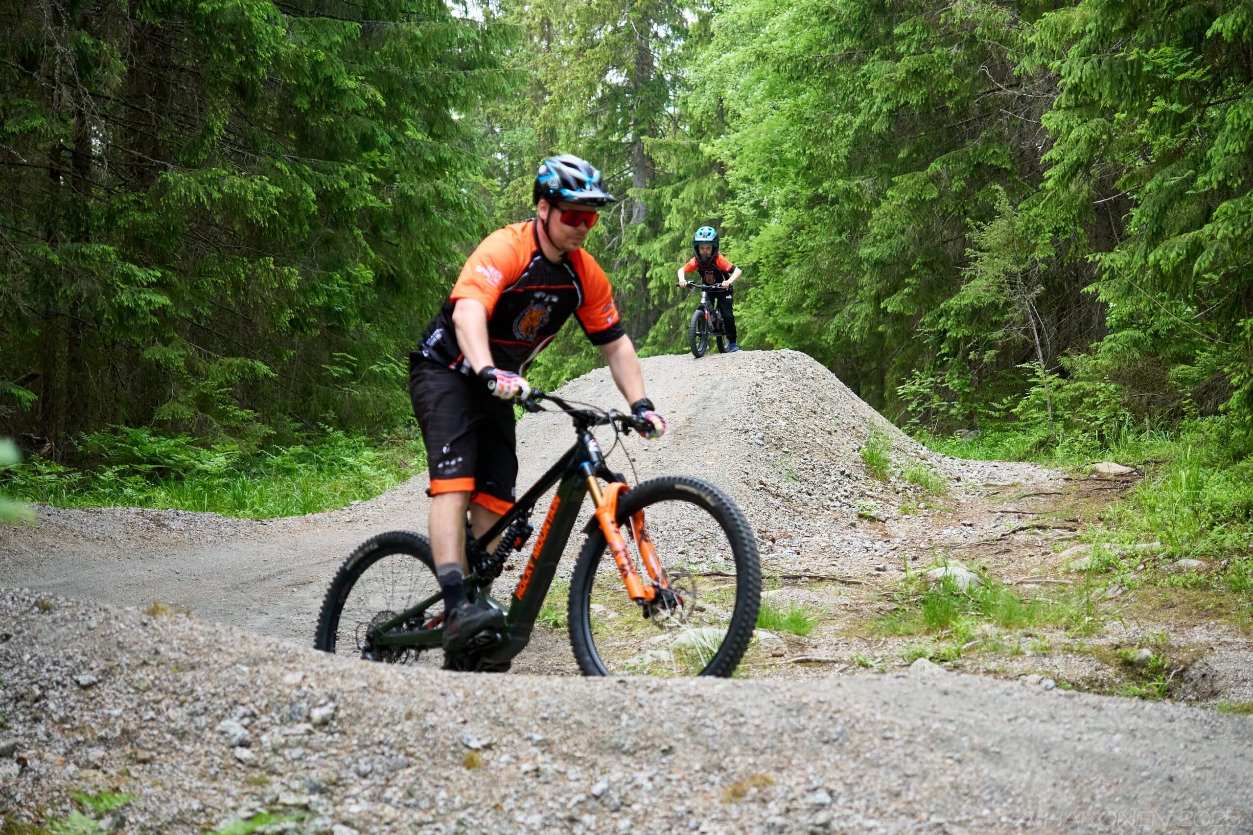 Mies ja poika maastopyöräilevät.