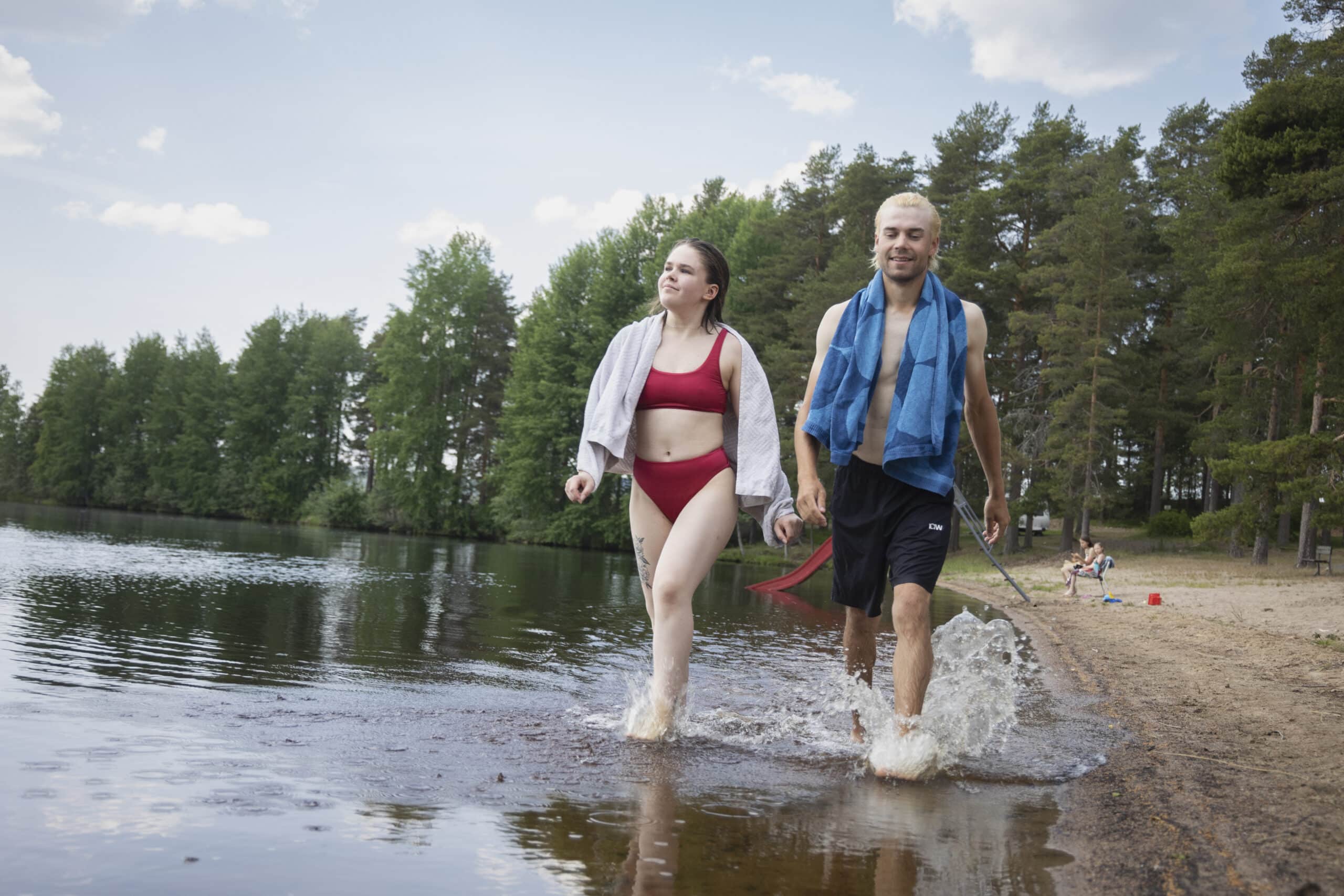 Pariskunta kävelee rantavedessä.