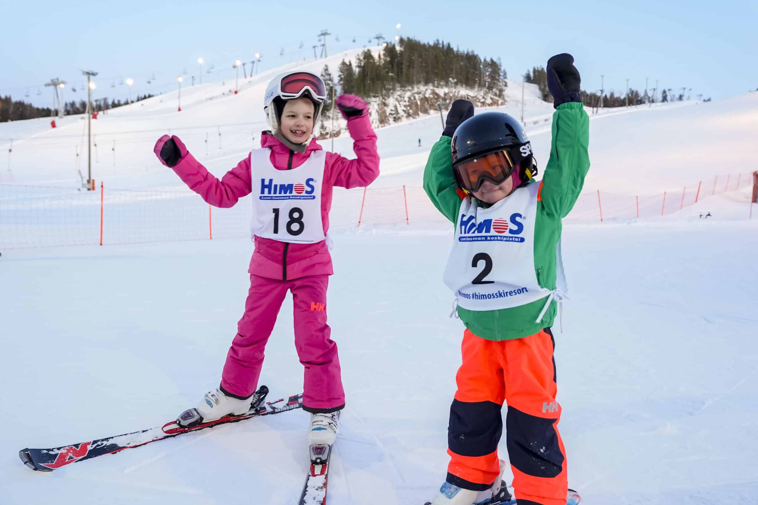 Kaksi lasta laskettelurinteessä