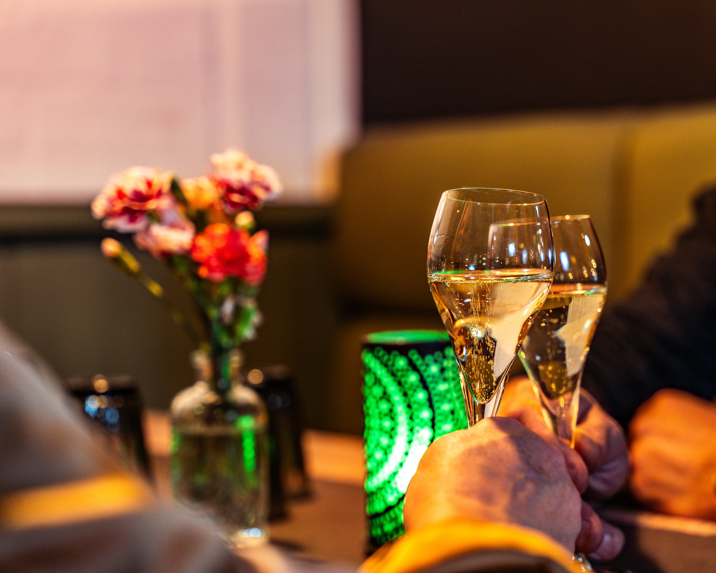 Shampanja lasit ja kukka-asetelam ravintola pöydällä