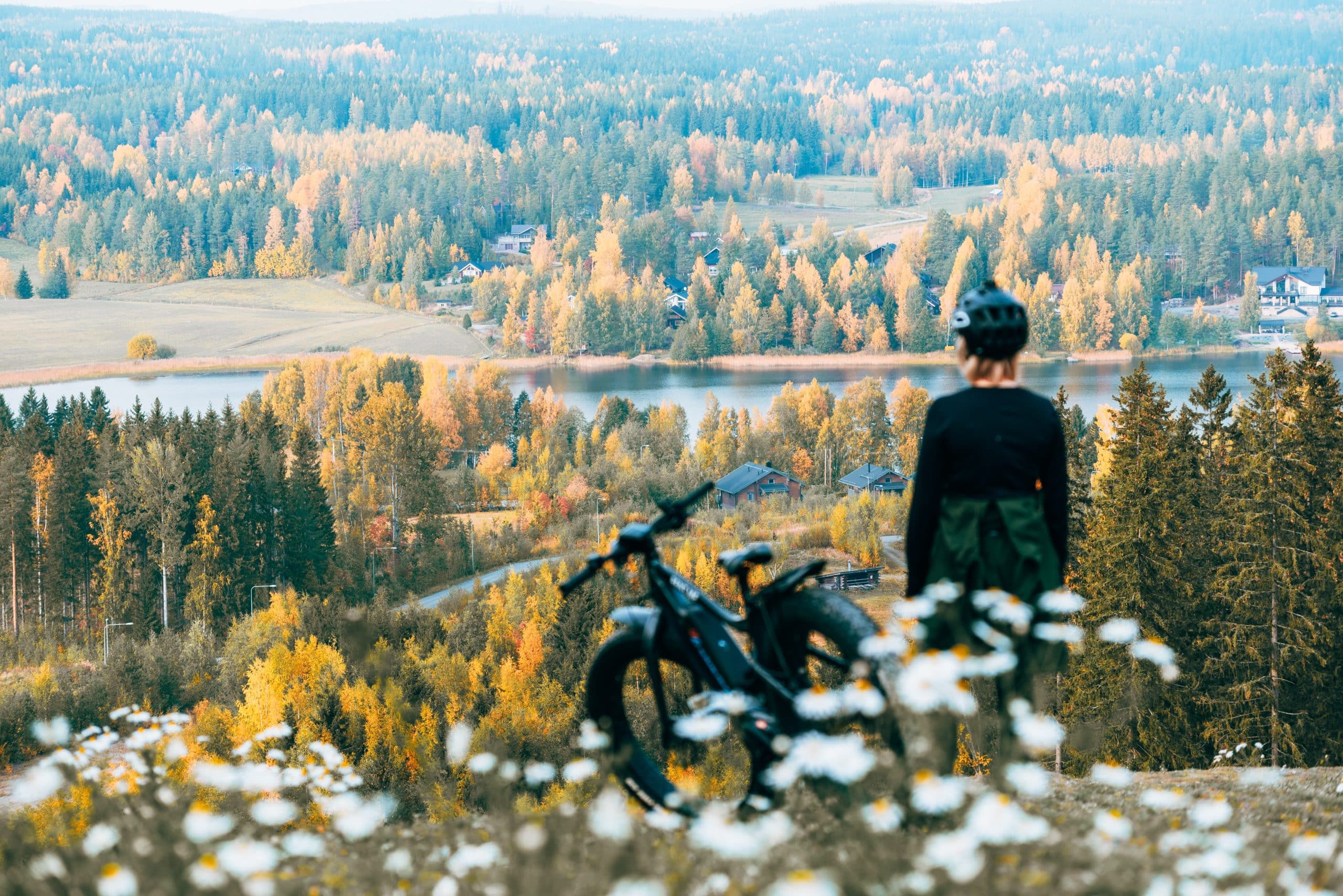 Pyöräilijä katsoo syksyistä maisemaa Himoksen huipulta