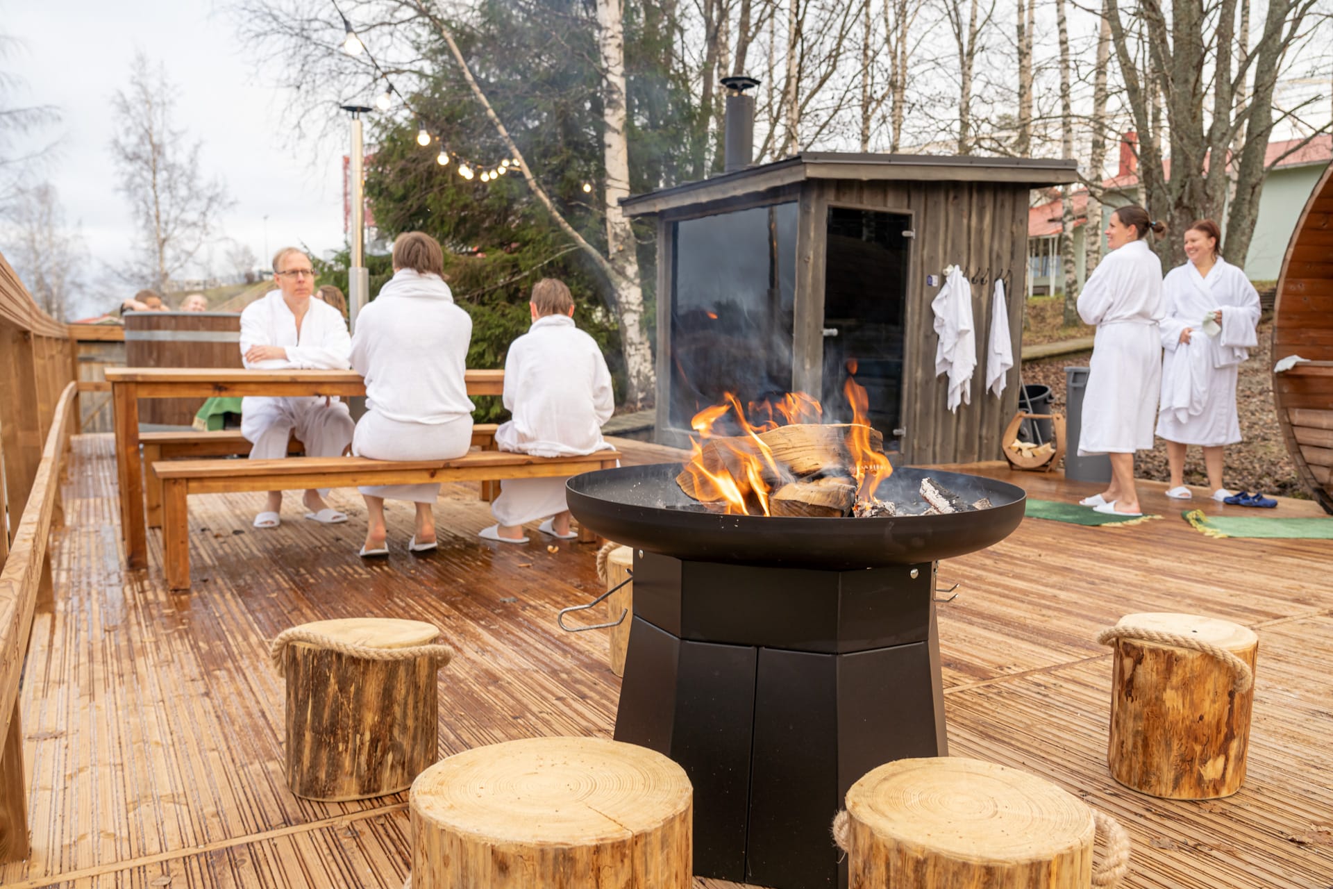 Ihmisiä rentoutuu saunapihalla