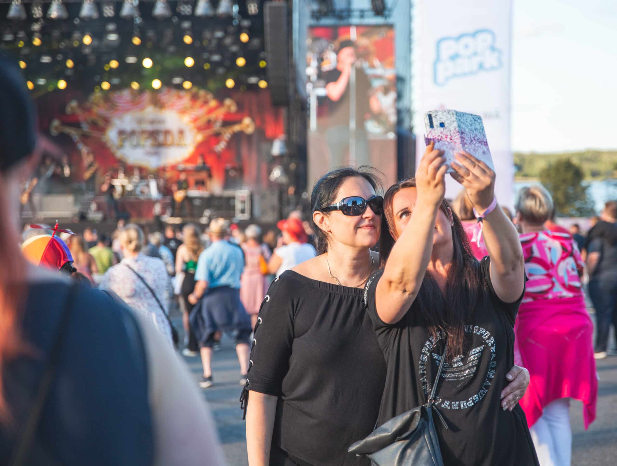 Kaksi henkilöä ottaa selfien festareilla