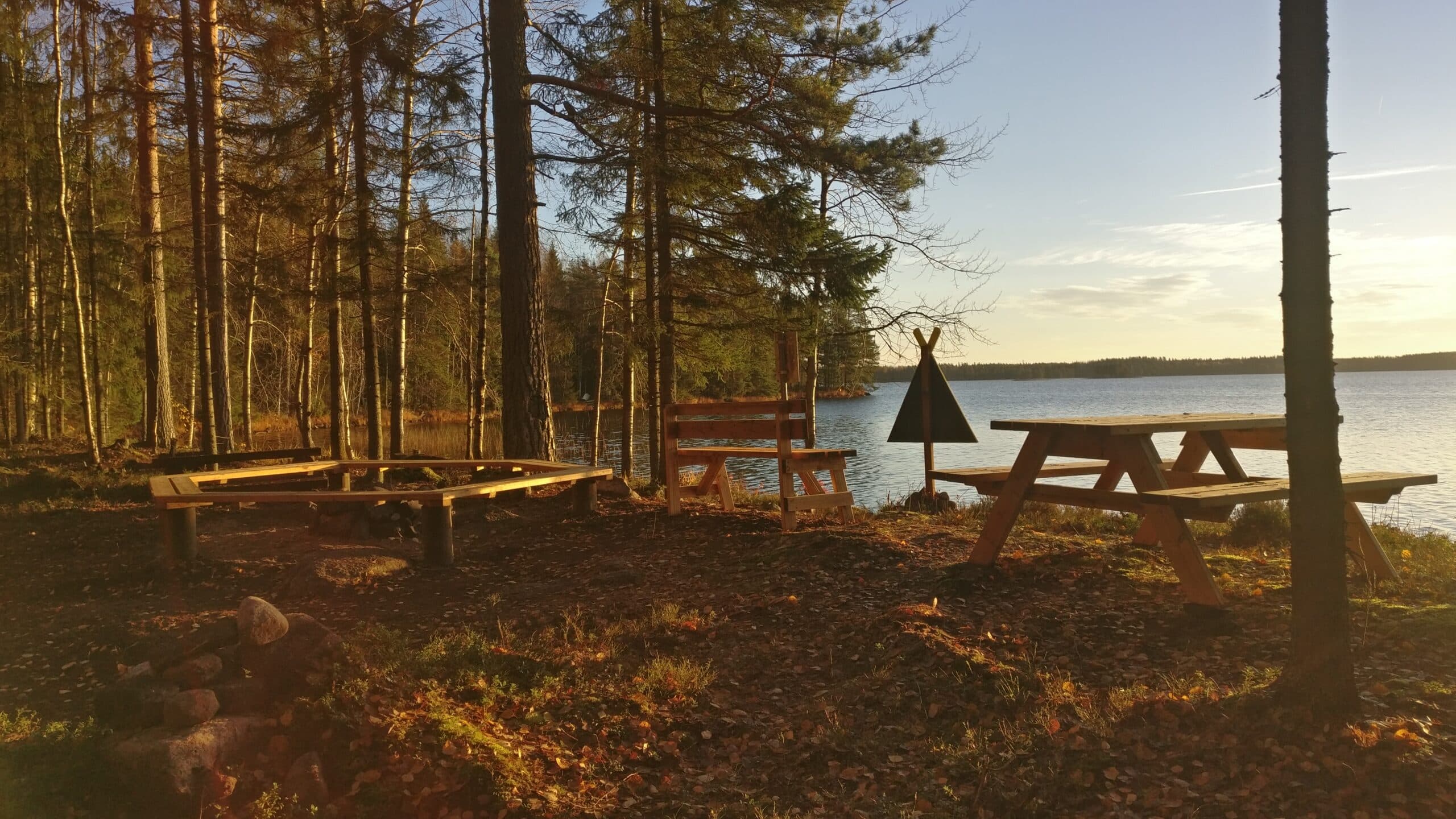 Nuotiopaikka ja pöytäryhmä järven rannalla