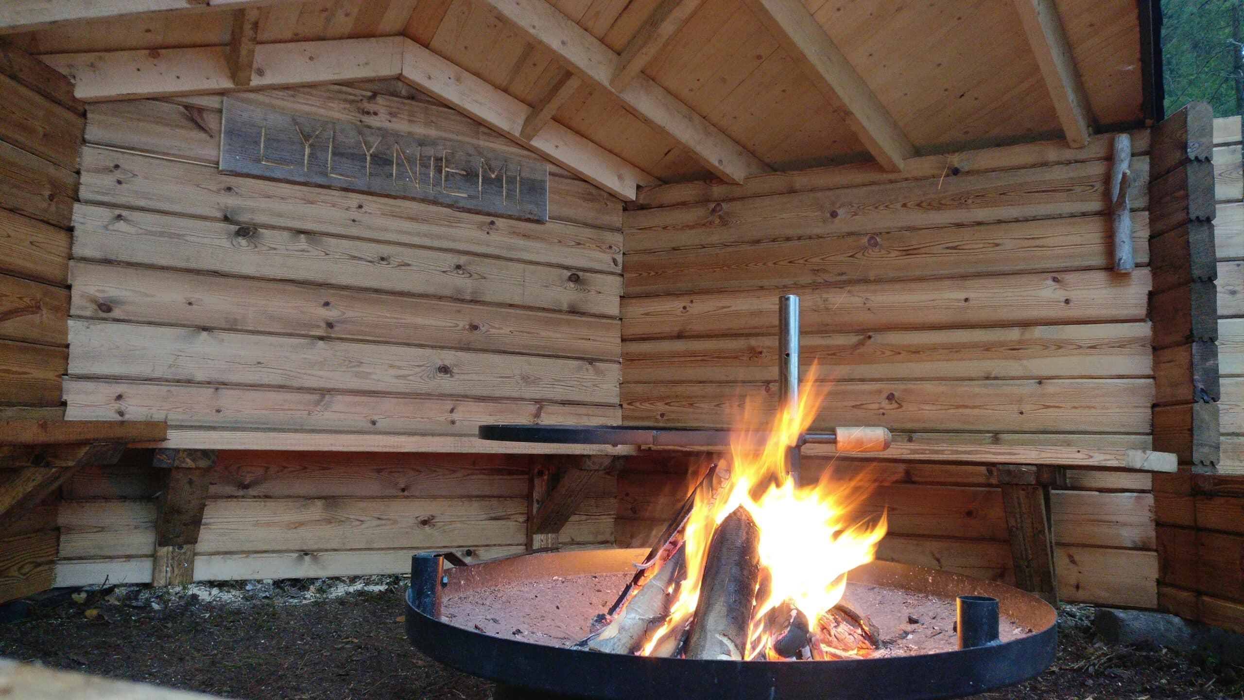 Laavu ja nuotio jossa palaa tuli