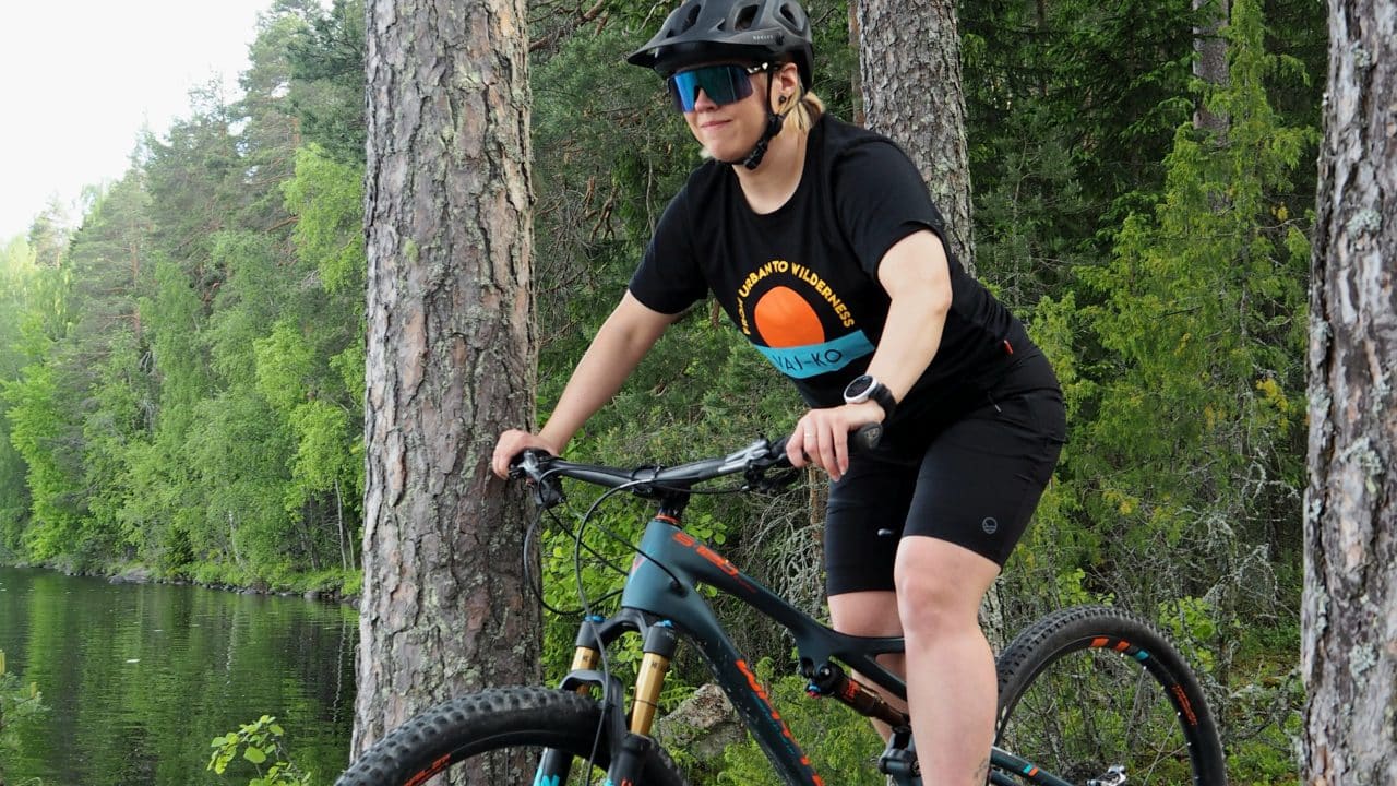 Maastopyöräilijä kesällä metsäpolulla