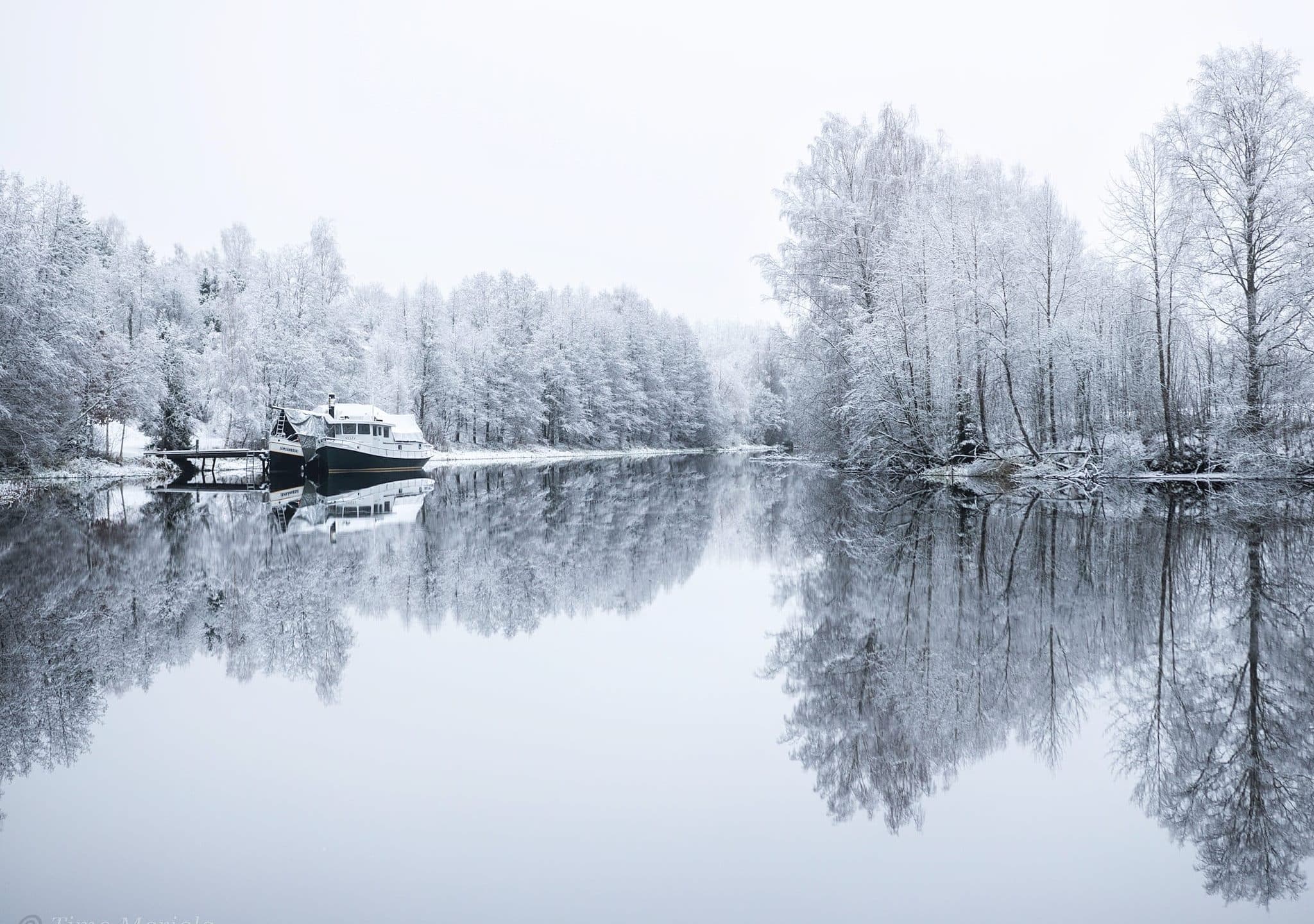 Lumen peittävät puut sulan joen varrella