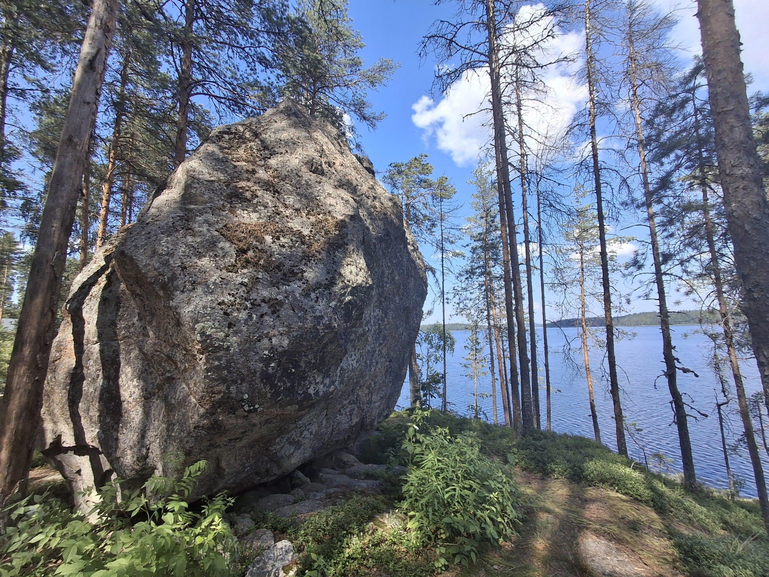 Suuri kivilohkare järven rannalla