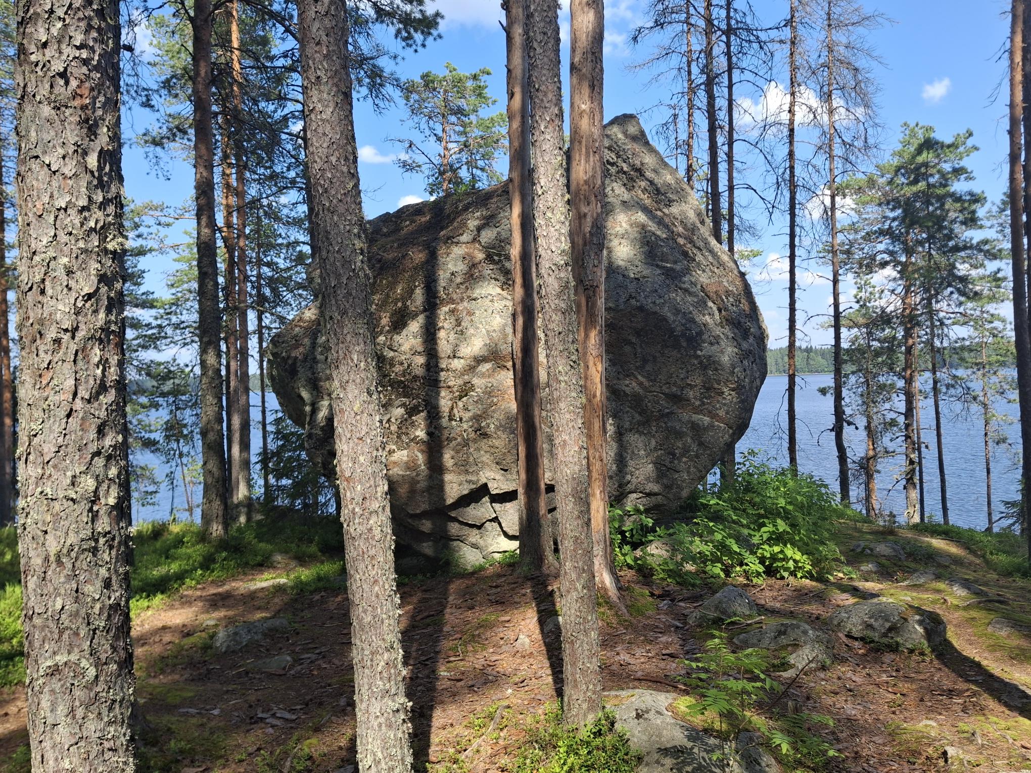 Suuri kivilohkare järven rannalla